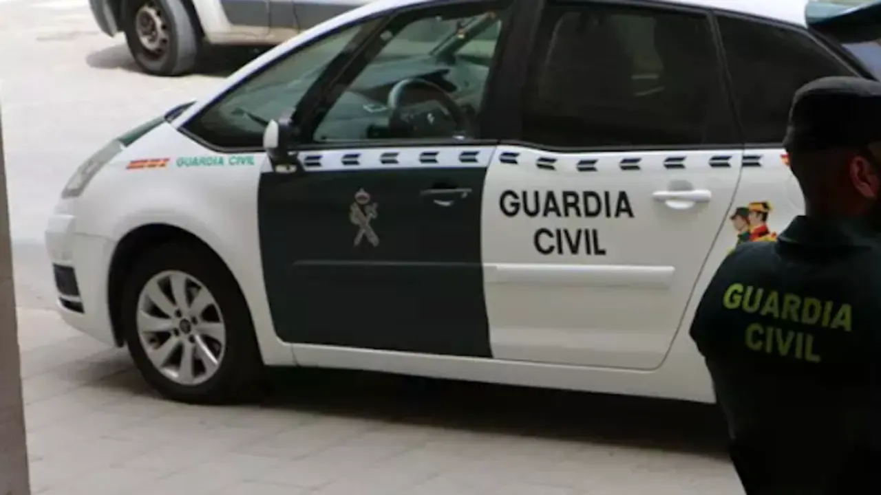 Coche y agente de la Guardia Civil. / GC