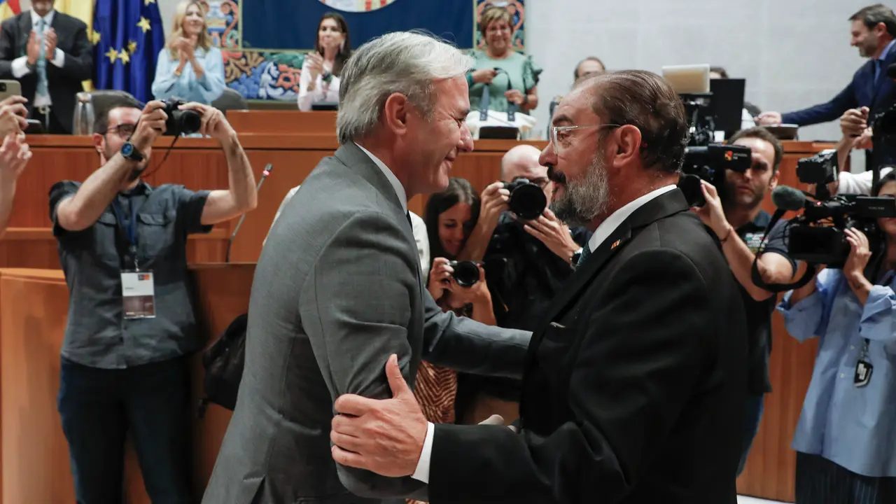 El popular Jorge Azcón (i) saluda a su antecesor en el cargo, Javier Lambán tras ser investido como presidente de Aragón durante la segunda jornada de debate este jueves, en Zaragoza. : Javier Belver