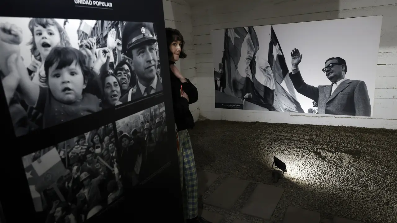 Una mujer observa im&aacute;genes del expresidente chileno, Salvador Allende (d). / Elvis Gonz&aacute;lez