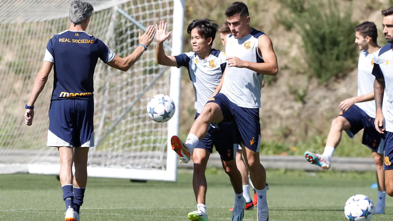 El entrenador de la Real Sociedad, Imanol Alguacil (i), saluda al centrocampista japon&eacute;s, Take Kubo (c). / EFE
