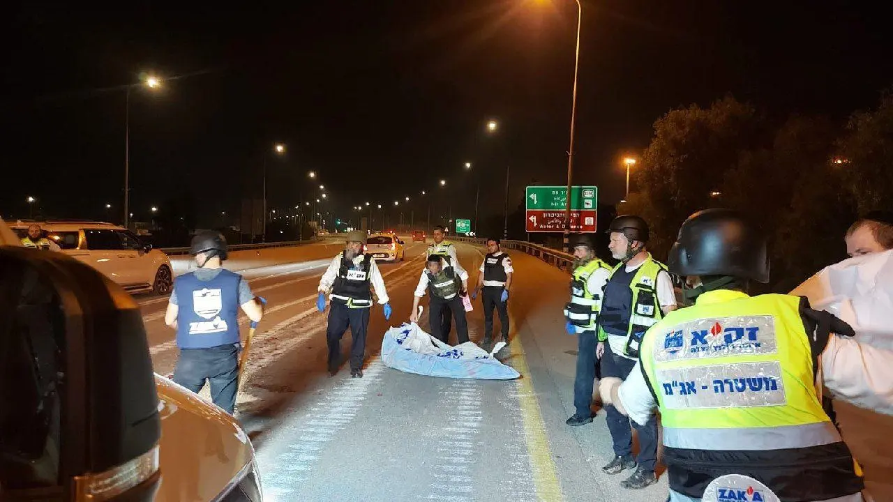 Las autoridades israel&iacute;es recogiendo un cad&aacute;ver de la carretera.