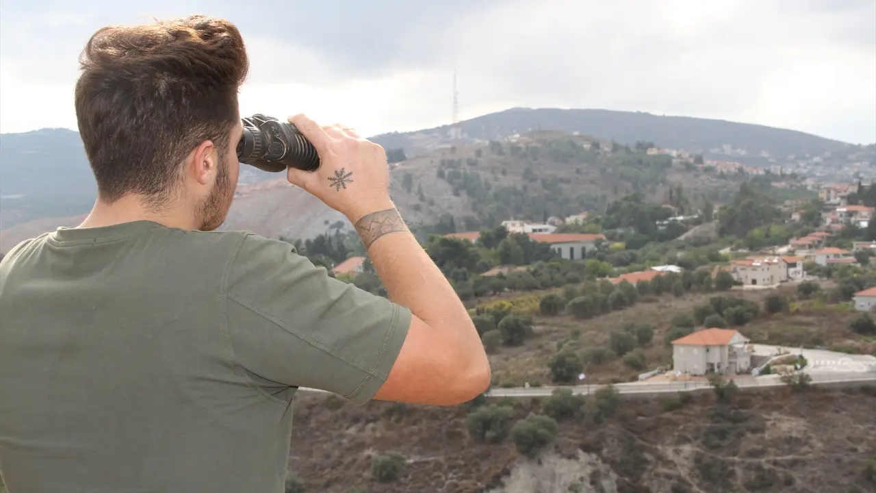 Un hombre observa con unos binoculares la situaci&oacute;n en la zona de Israel. EP / Taher Abu Hamdan
