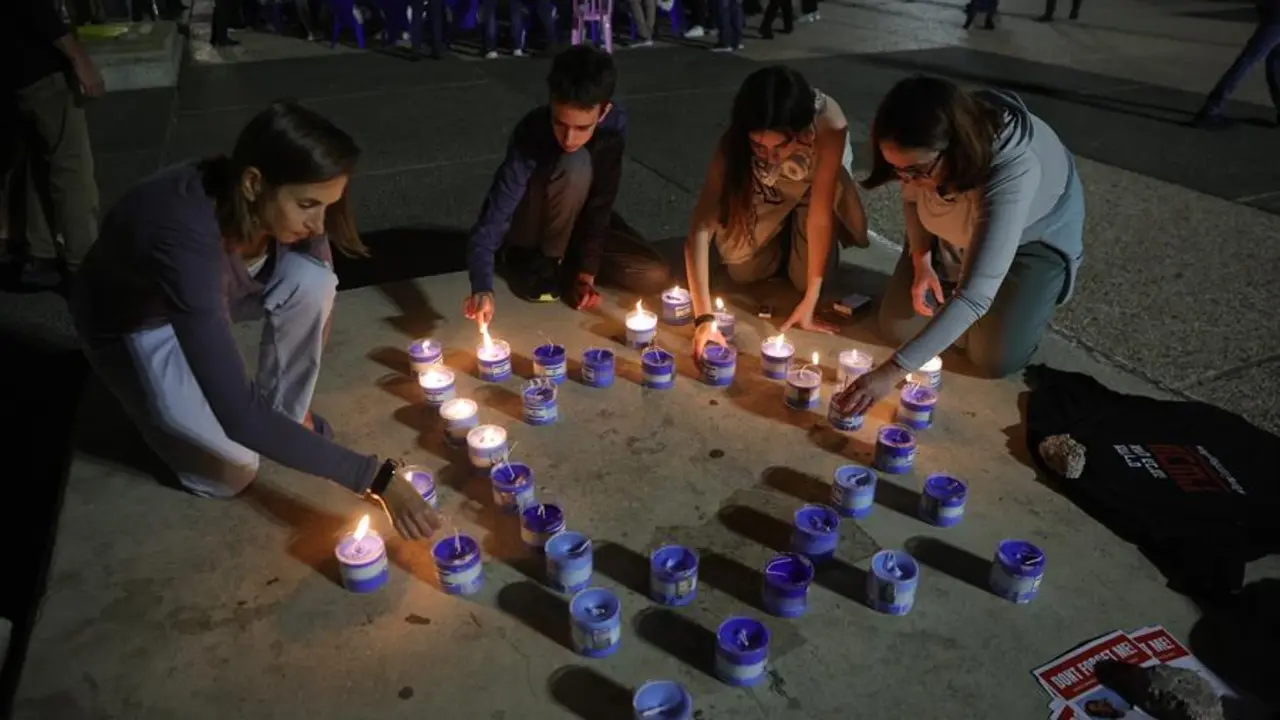 Cuatro personas encienden velas por la liberaci&oacute;n de los rehenes secuestrados por Ham&aacute;s. EFE / ABIR SULTAN
