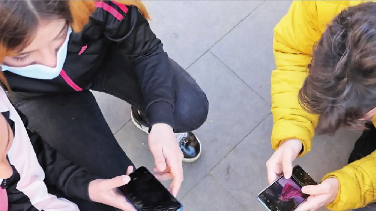 Varios j&oacute;venes reunidos viendo sus tel&eacute;fonos m&oacute;viles. / AlerTa