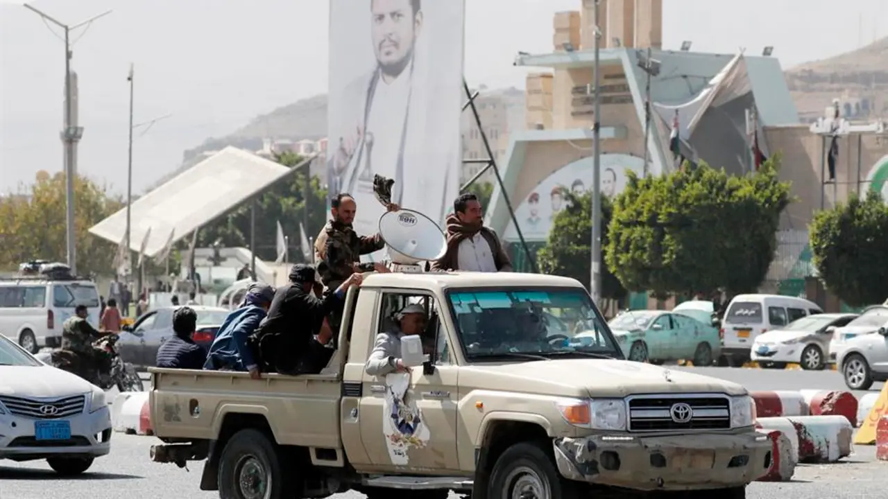 Simpatizantes hut&iacute;es viajan en un veh&iacute;culo pasando junto a una pancarta que representa al m&aacute;ximo l&iacute;der hut&iacute;, Abdul-Malik al-Houthi, en una calle de San&aacute;, Yemen. EFE / Yahya Arhab