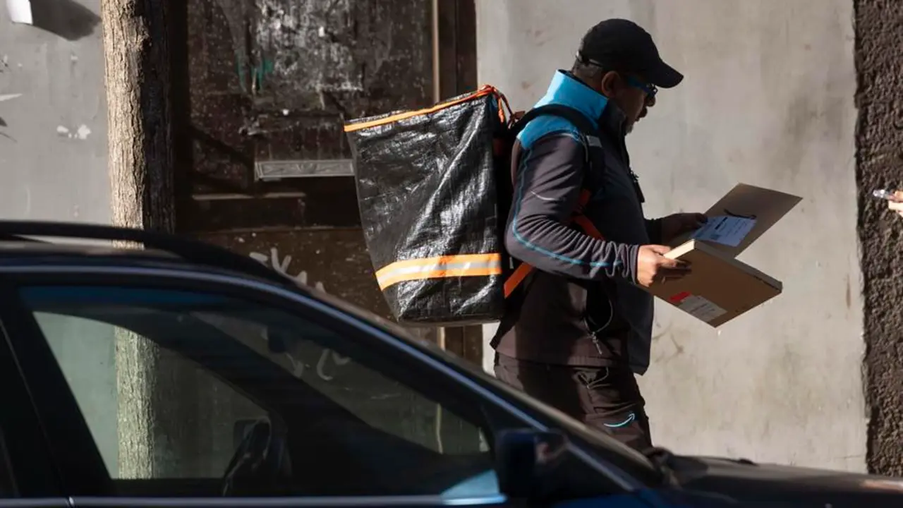 hombre reparte paquetes en una calle de Santander. EFE / Pedro Puente Hoyos