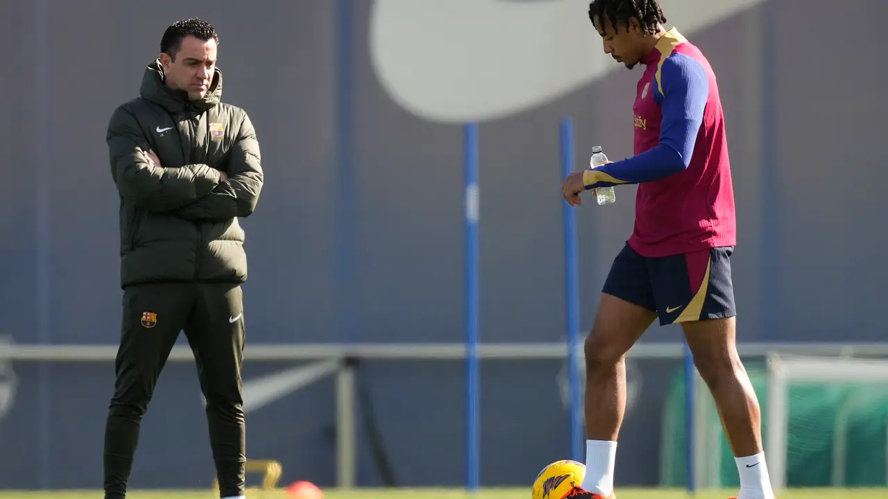 El entrenador del FC Barcelona, Xavi Hernandez, y el jugador Jules Kound&eacute; (d), durante el entrenamiento del equipo azulgrana. / Enric Fontcuberta.