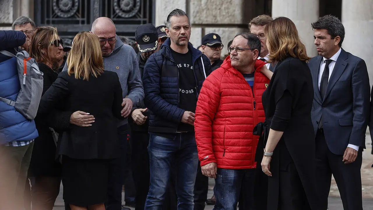El presidente de la Comunidad Valenciana, Carlos Maz&oacute;n (d), y la alcaldesa de Valencia, Mar&iacute;a Jos&eacute; Catal&aacute; (2d), junto a familiares y vecinos de los fallecidos y el portero del edificio, Juli&aacute;n (3d), durante el minuto de silencio por las v&iacute;ctimas del incendio del barrio de Campanar. EP / Rober Solsona