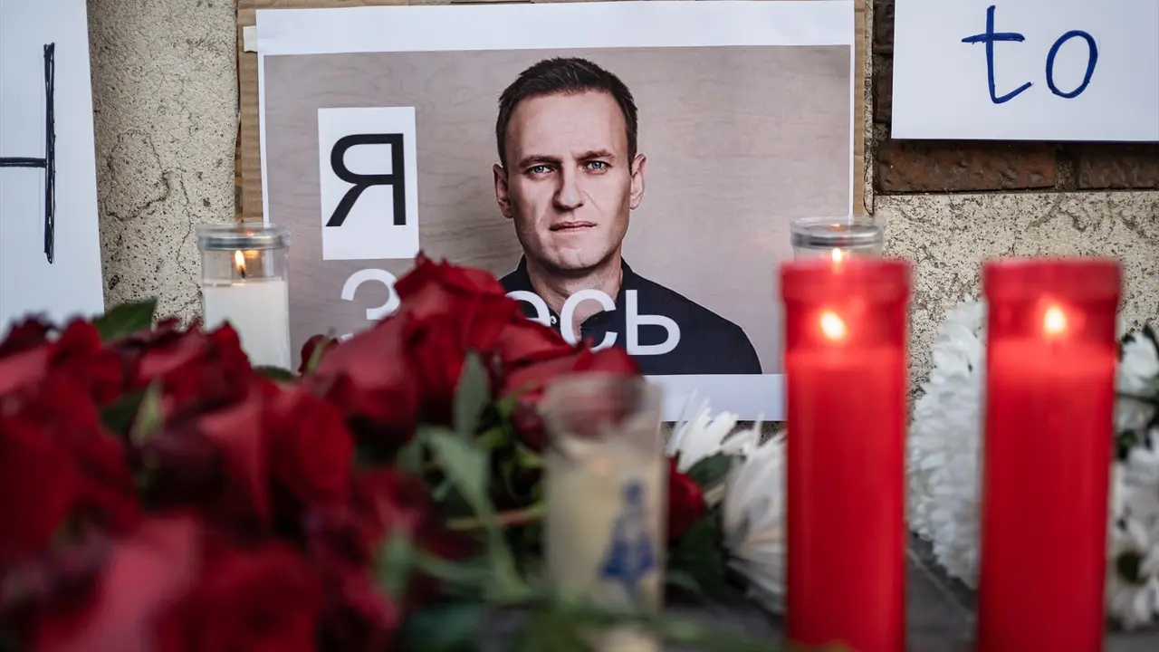 La foto del opositor ruso, Alex&eacute;i Navalni, junto a unas flores y velas tras su muerte. EP / Diego Radam&eacute;s