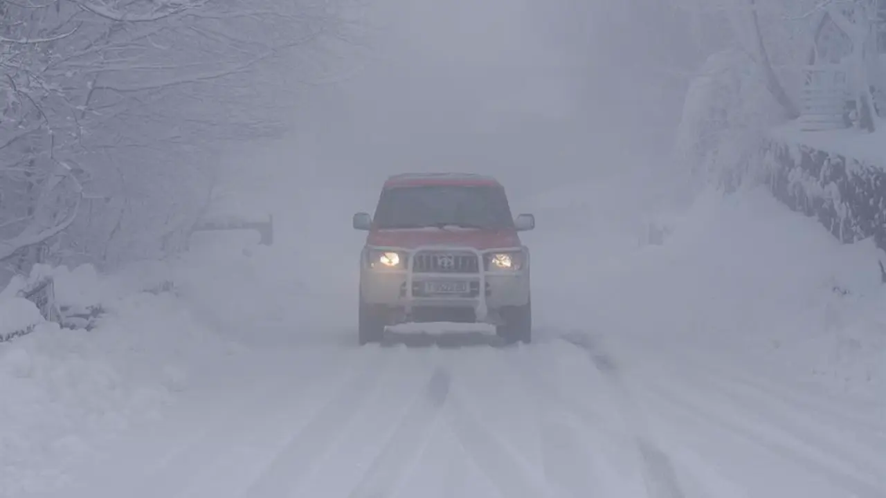 Un veh&iacute;culo circula por una carretera cubierta de nieve. / Archivo/ EFE/ Eiseo Trigo