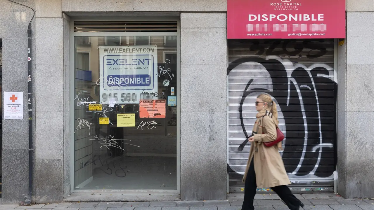 Una persona pasa por delante de un comercio cerrado. EP / Eduardo Parra