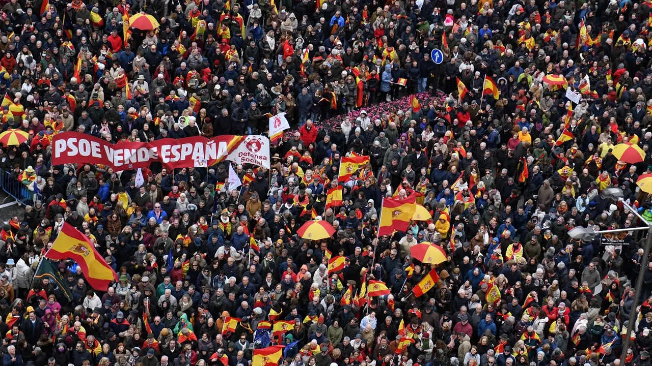 Decenas de personas durante una concentraci&oacute;n donde piden la dimisi&oacute;n de Pedro S&aacute;nchez, y un cartel con la frase "PSOE vende Espa&ntilde;a". EP / Fernando S&aacute;nchez