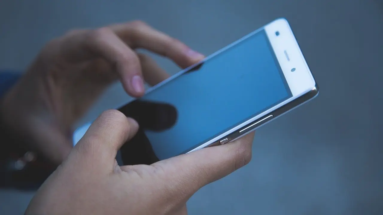 Una persona con un tel&eacute;fono m&oacute;vil. EP