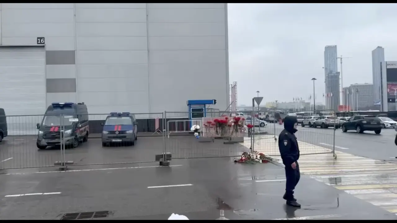 La gente lleva flores y juguetes al edificio del Ayuntamiento de Crocus.