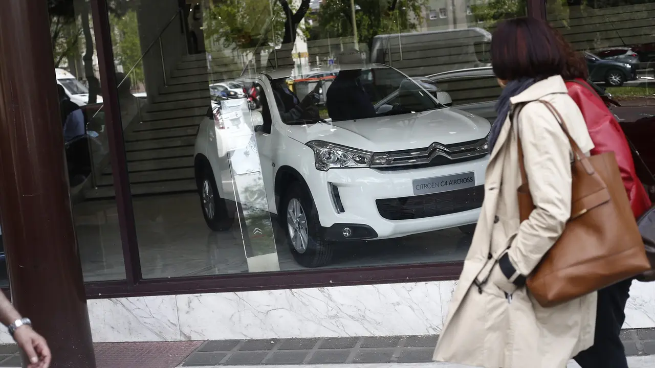 Una mujer caminando frente a un concesionario. EP / Archivo