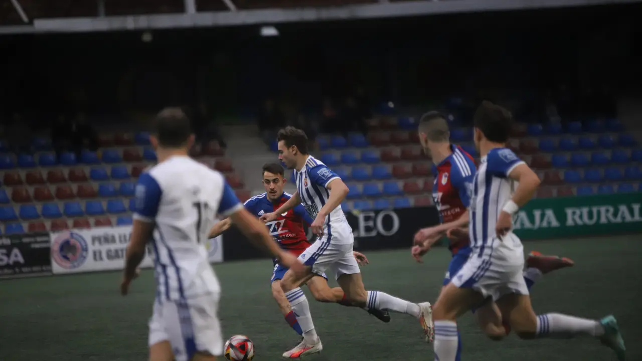 Basurto controla un bal&oacute;n bajo la presi&oacute;n del Langreo en el partido de ida. / N&eacute;stor Revuelta Zarzosa