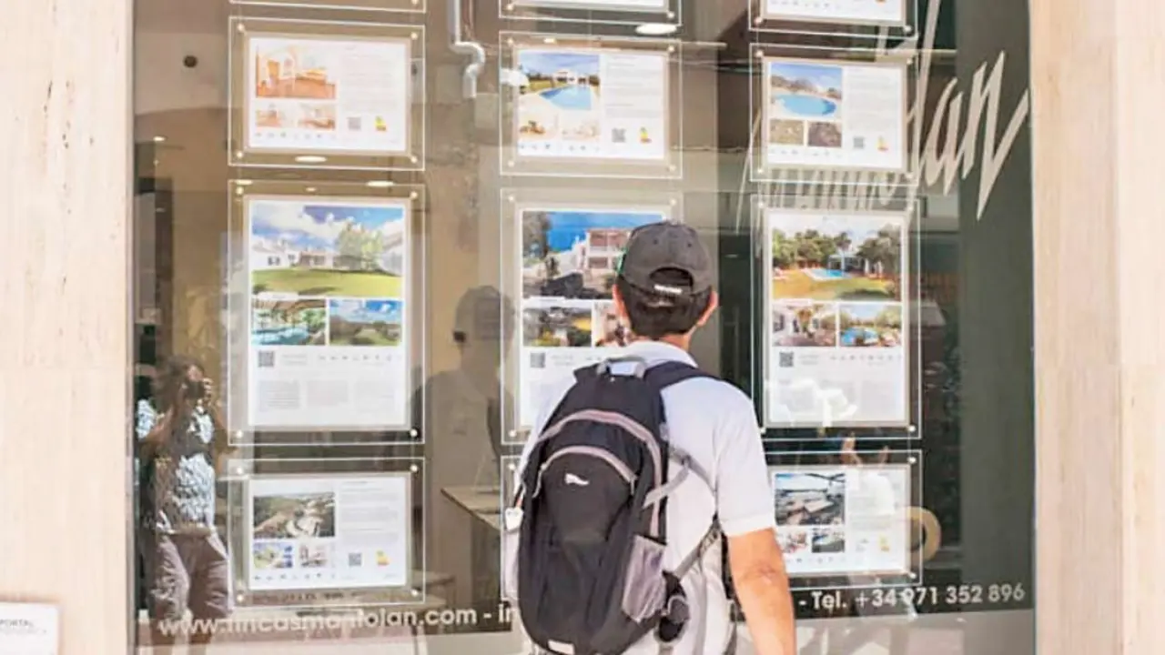 Un hombre observa carteles de viviendas en venta. / alerta