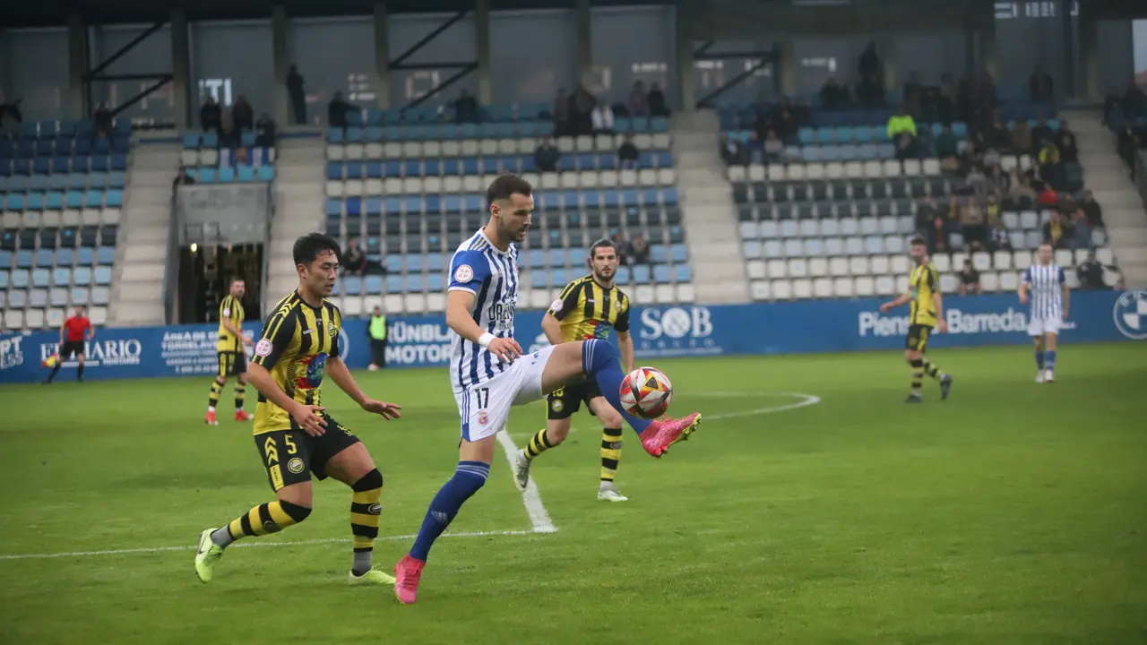 Javi Delgado controla un bal&oacute;n ante la presi&oacute;n del Cay&oacute;n en el partido de ida. / N&eacute;stor Revuelta Zarzosa