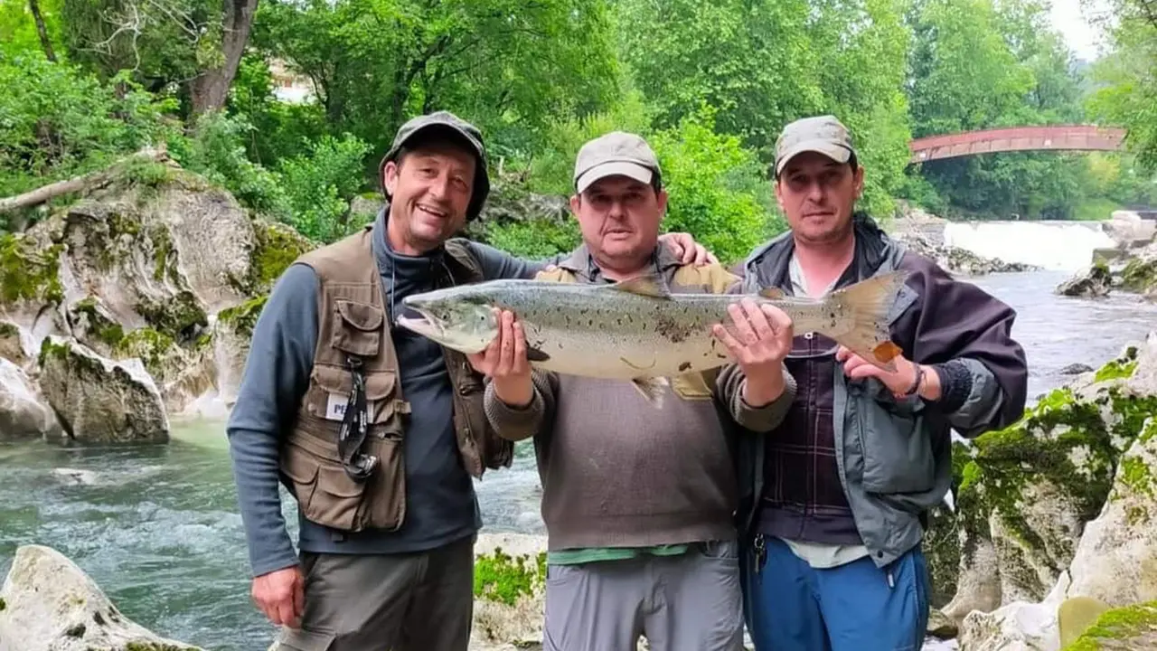 Fotograf&iacute;a de tres pescadores con un salm&oacute;n en el coto de pesca Puente Viesgo.