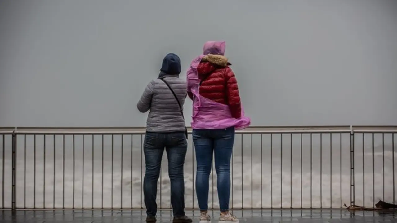 Dos mujeres en el paseo mar&iacute;timo durante un episodio de lluvias. / EP
