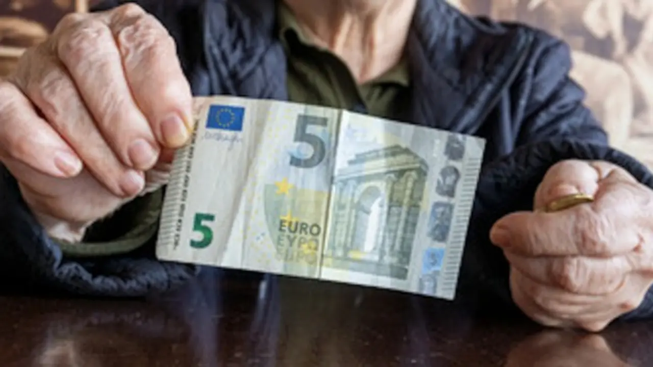 Una pensionista ense&ntilde;a un billete de cinco euros. / ALERTA