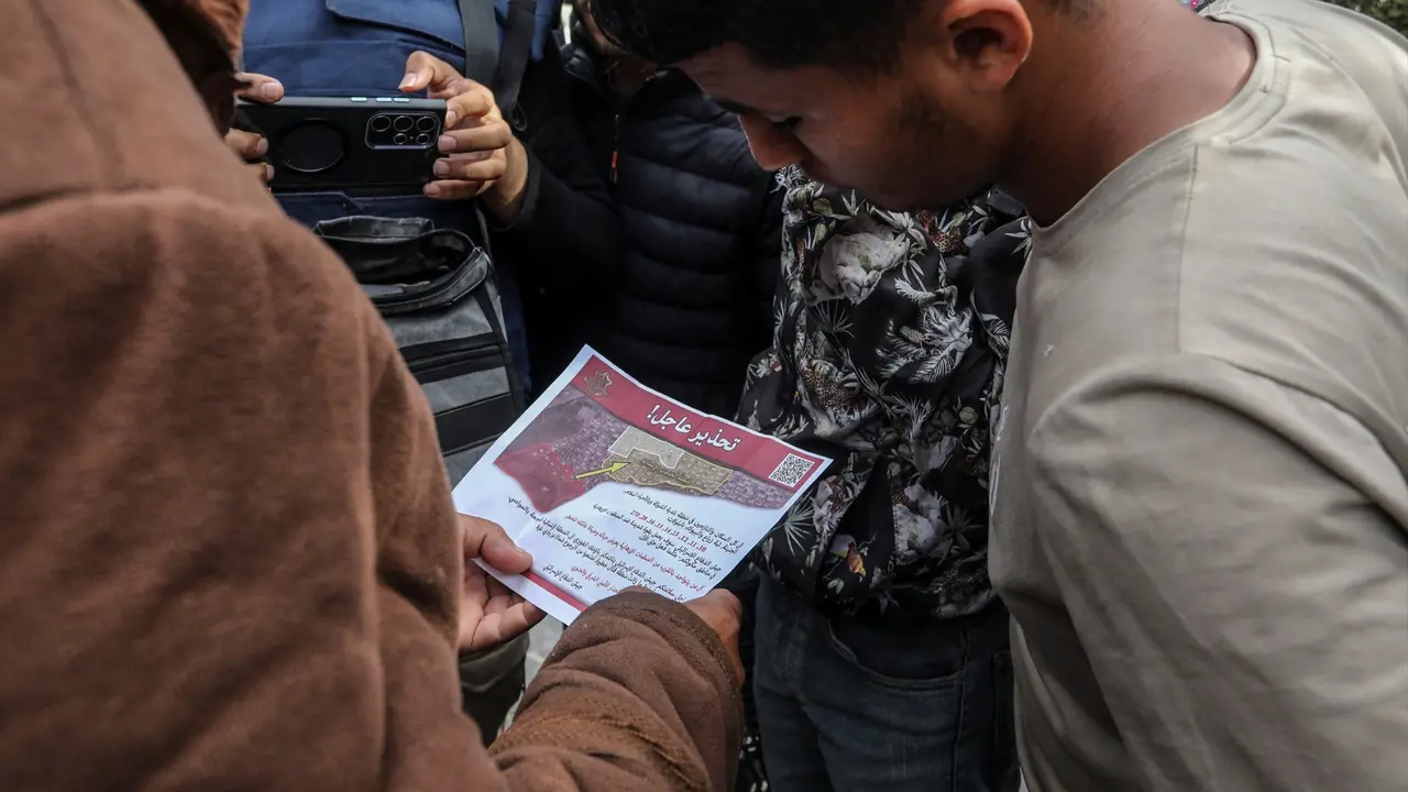 Los palestinos sostienen un panfleto lanzado por aviones militares del ej&eacute;rcito israel&iacute; al este de la ciudad de Rafah, orden&aacute;ndoles evacuar y avanzar hacia el oeste de la ciudad y la ciudad de Khan Yunis. Abed Rahim Khatib