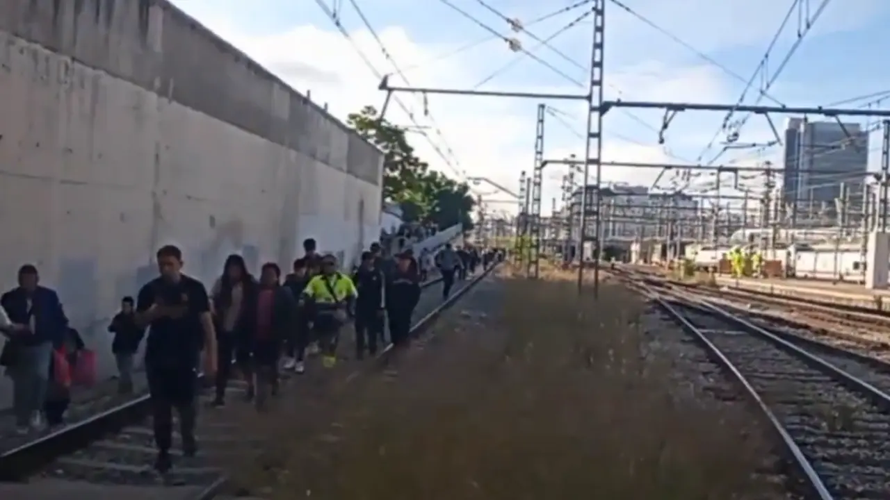 Los pasajeros caminando por las v&iacute;as del tren tras el incidente con el tren de cercan&iacute;as. / Captura de un v&iacute;deo