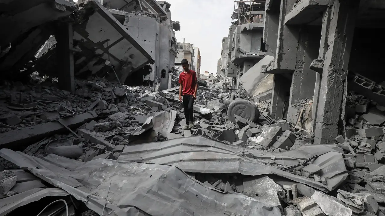 Un hombre caminando entre los escombros de unos edificios en Gaza.  Omar Naaman