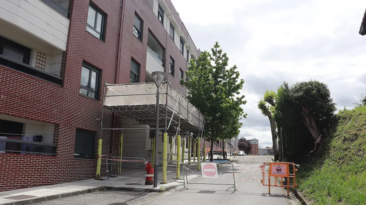Entrada acordonada y sin acceso debido a los problemas estructurales que preseenta la fachada de este bloque de viviendas. / Alerta