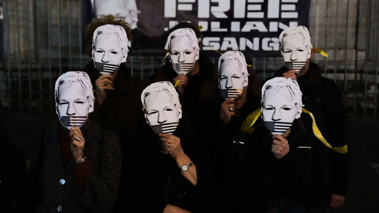 Varias personas con una m&aacute;scara con la cara de Julian Assange. / Antonio Balasco / Archivo