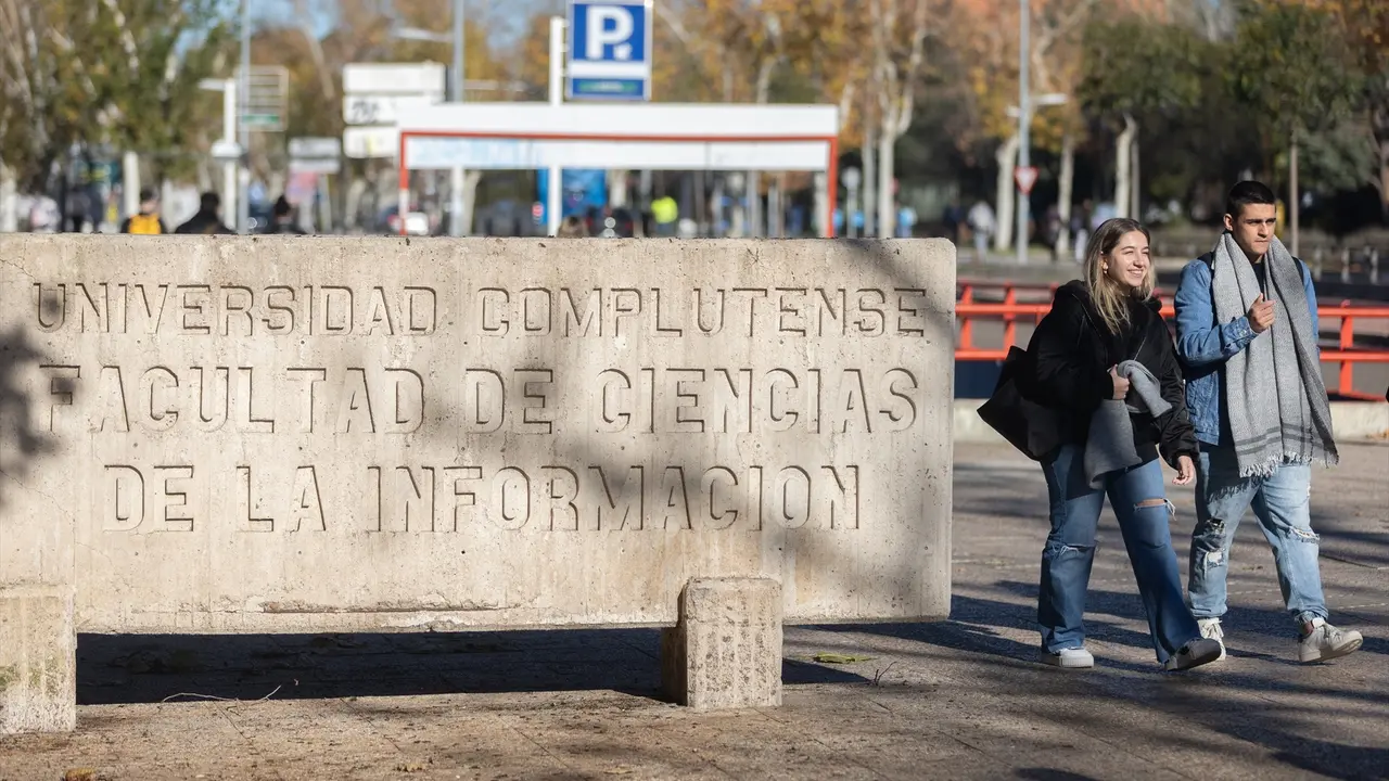 Dos personas caminan junto a la Facultad de Ciencias de la Informaci&oacute;n, en la Universidad Complutense de Madrid. Eduardo Parra / Archivo