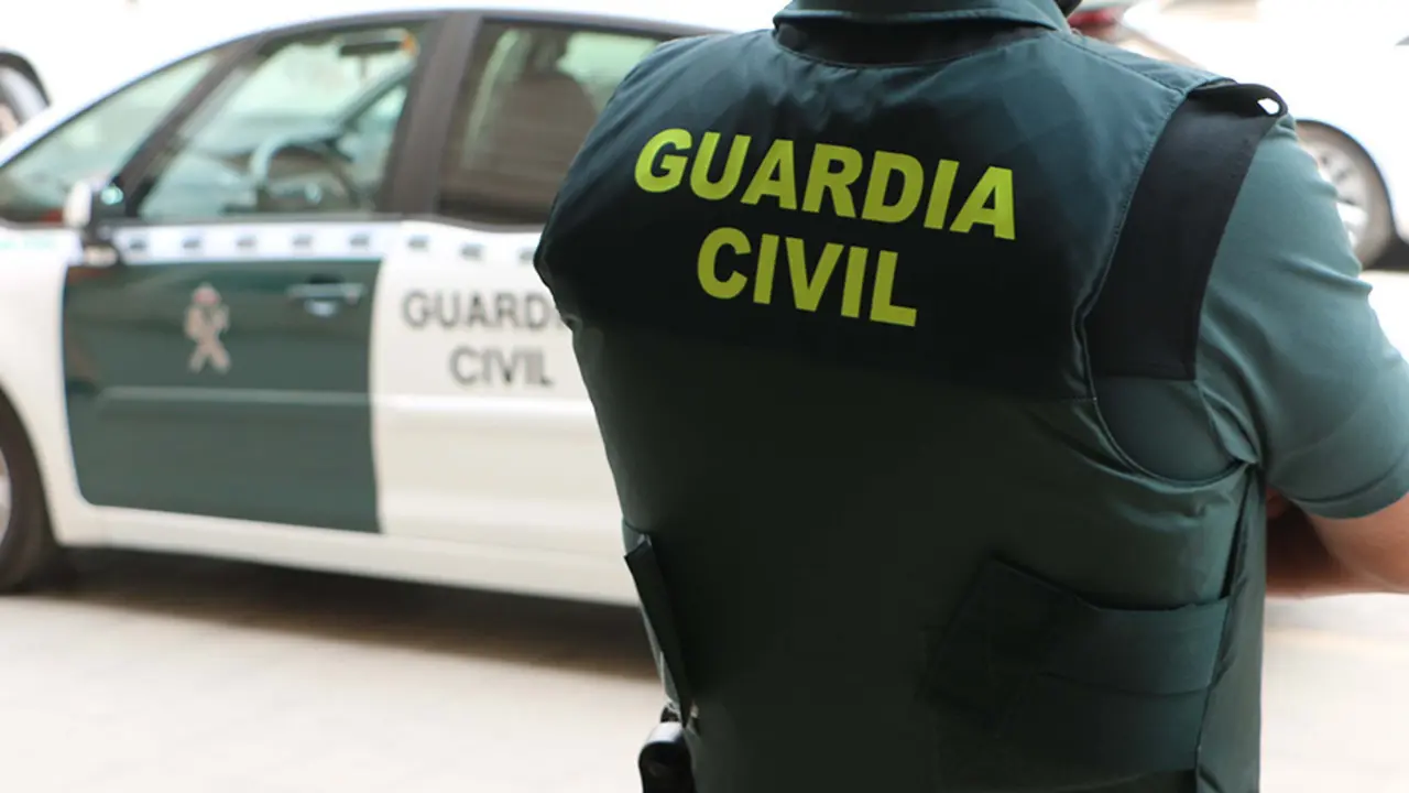 Un agente de la Guardia Civil, de espaldas, junto a un veh&iacute;culo oficial. / G.C.