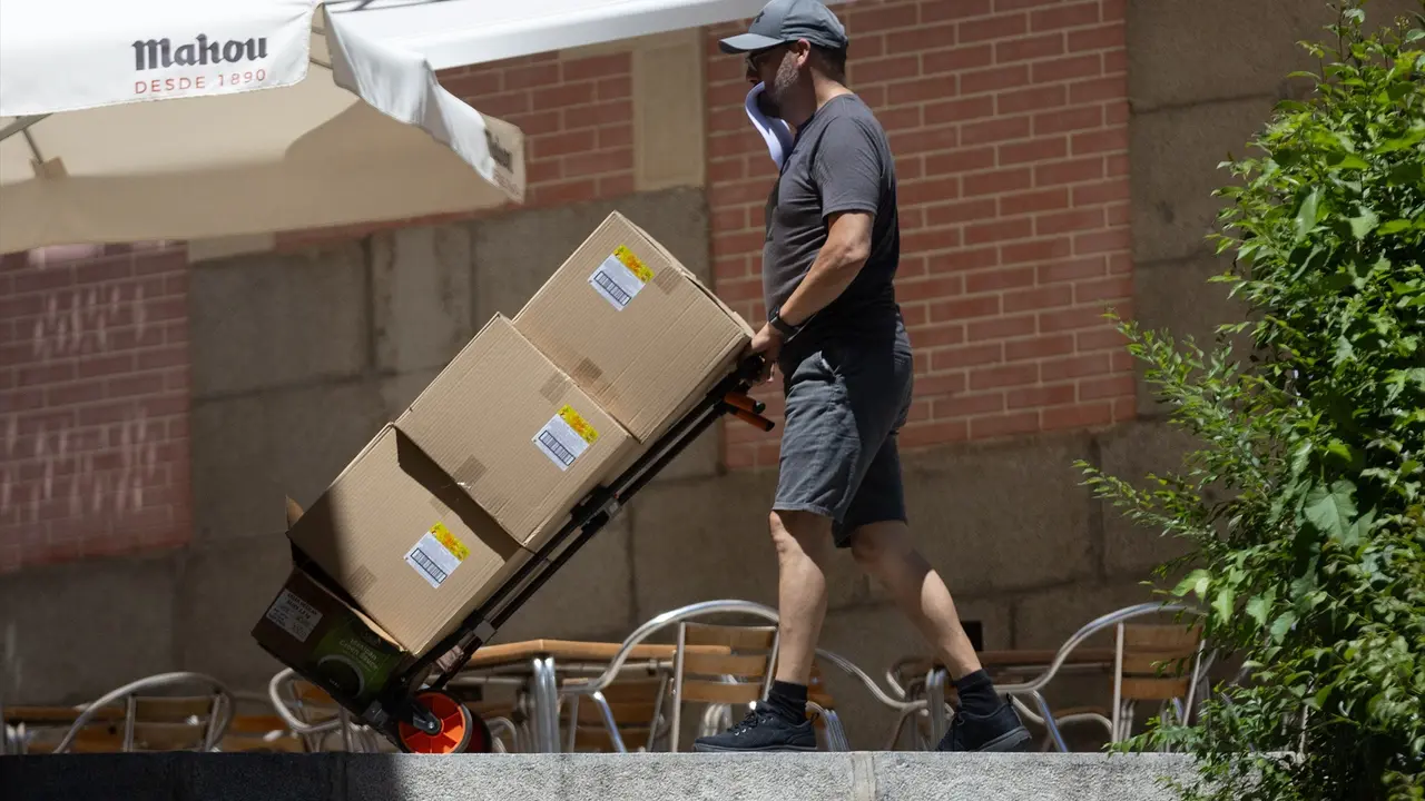 Un hombre sujeta varias cajas mientras las traslada. EP