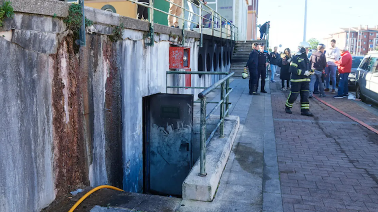 Bomberos y vecinos en las inmediaciones del incendio. / EP