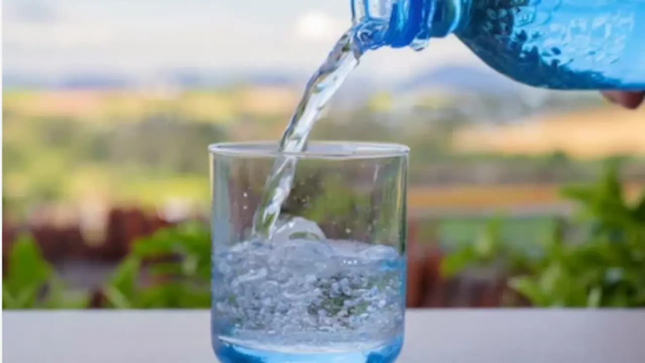 Una persona echando agua a un vaso. / A.S.