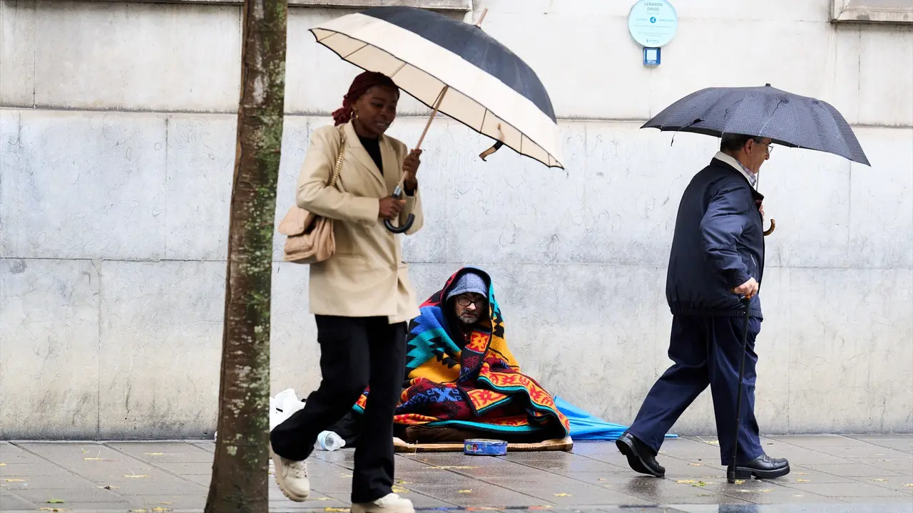 Varias personas se cubren de la lluvia con un paraguas. / EP