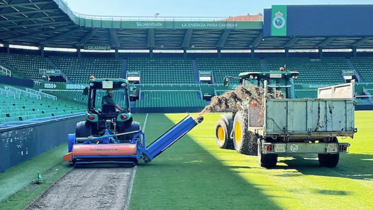 Varias maquinas en el cesped de la casa del Racing de Santander donde se puede apreciar el cesped levantado. / x