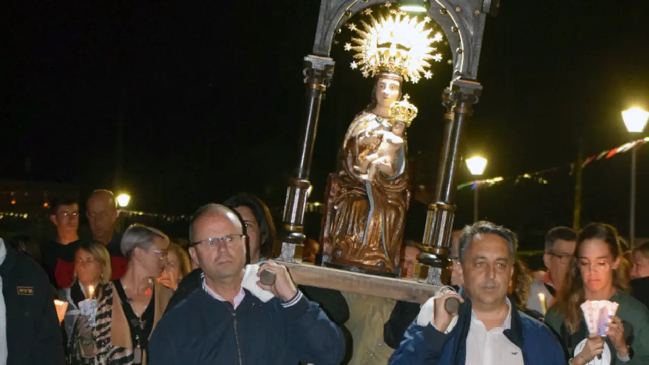 A la derecha, portando la estatuilla de la Virgen, el alcalde de Pi&eacute;lagos durante la procesi&oacute;n. / ALERTA
