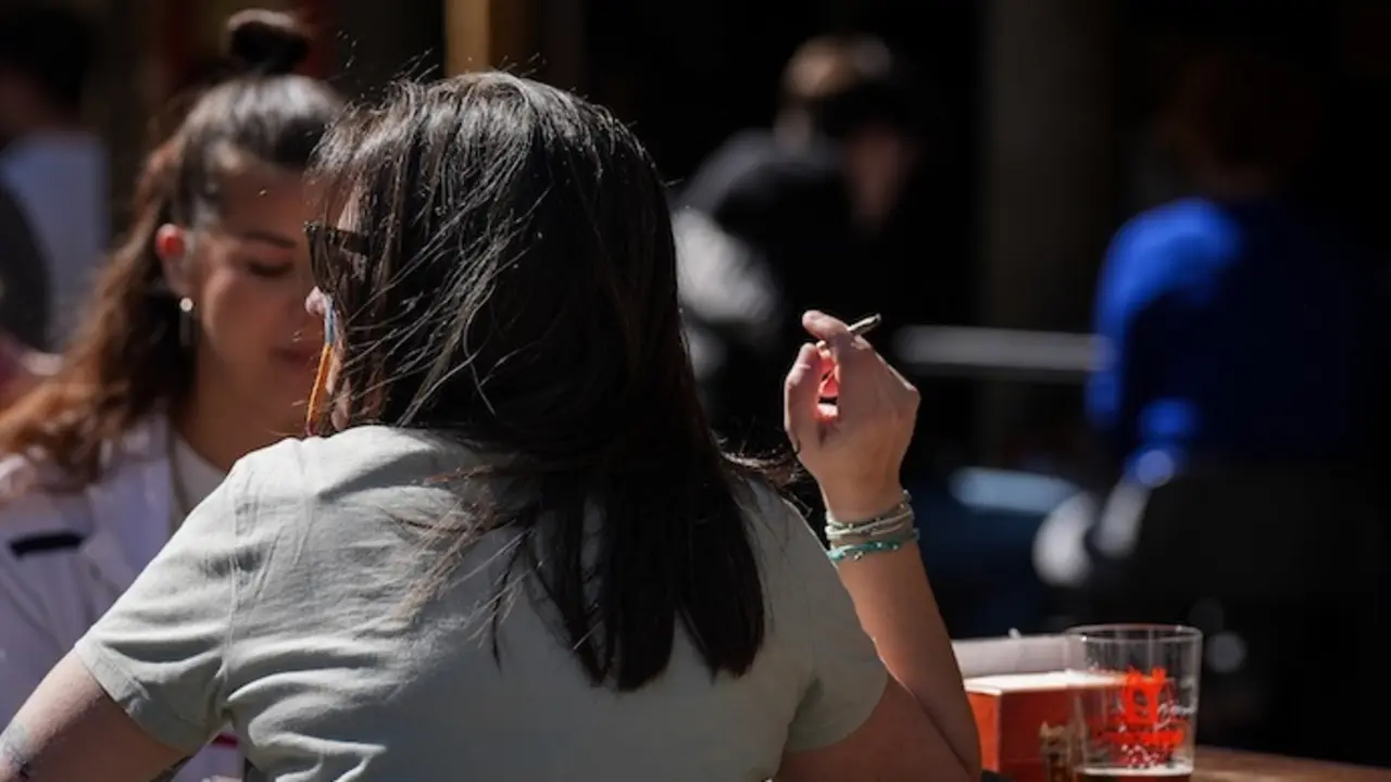 Una persona fumando en una terraza. EP