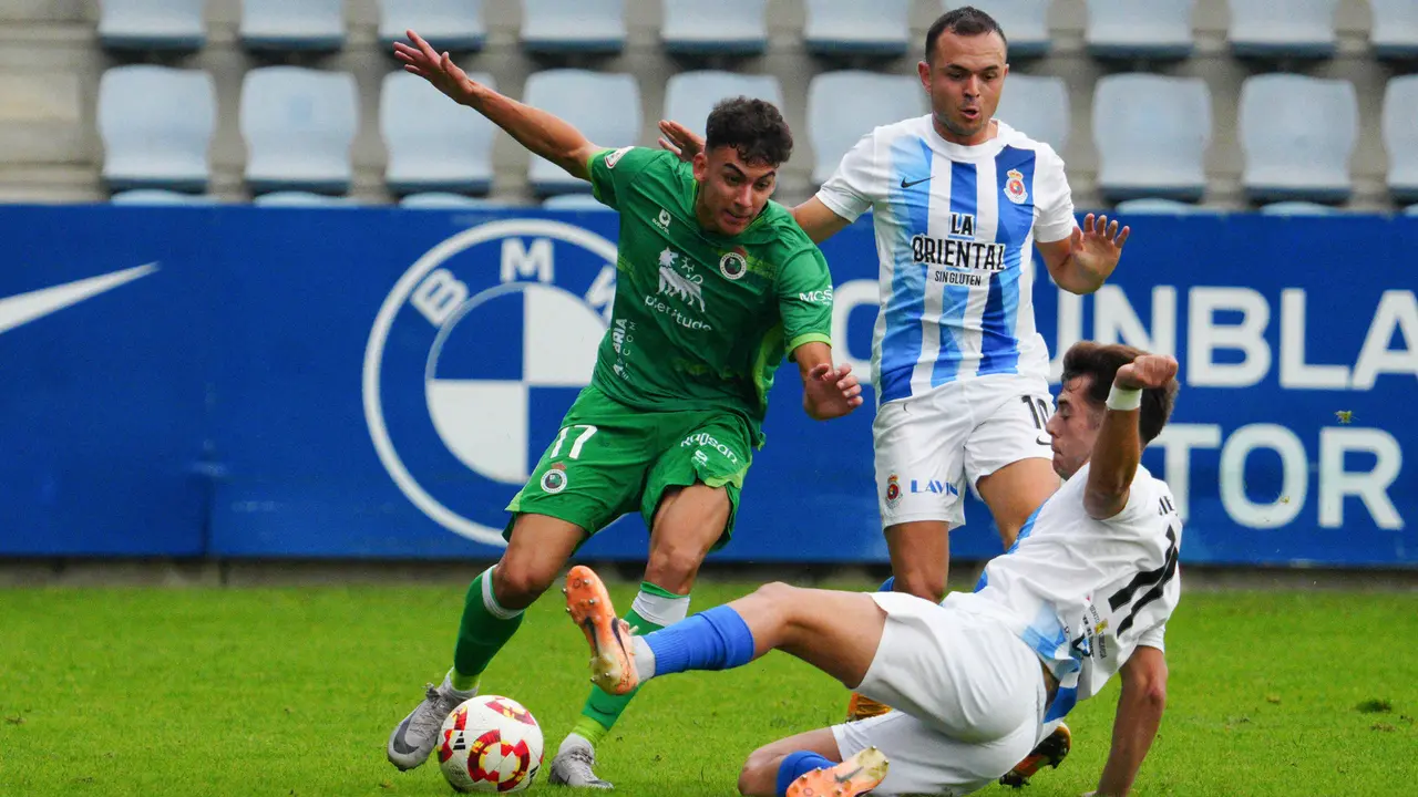 Diego Campo, de la Gimn&aacute;stica, se tira al suelo para frenar un ataque del Rayo. / Racing Cantera