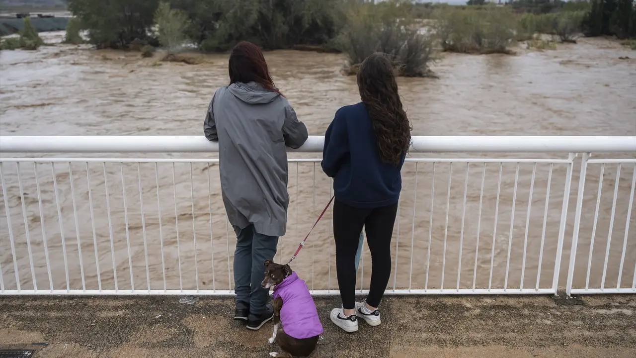 Varias personas observan la crecida del r&iacute;o Magre, en Alfarp, Valencia. / Jorge Gil