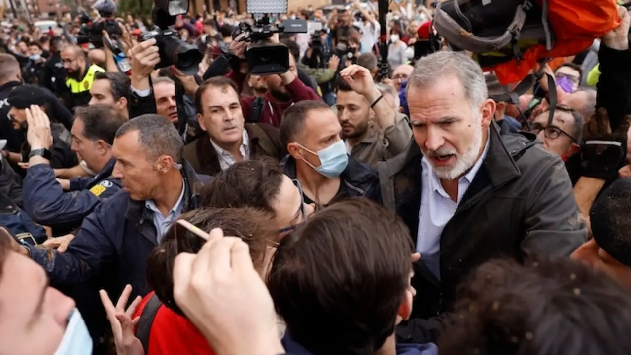 PAIPORTA (VALENCIA), 03/11/2024.- El rey Felipe habla con vecinos afectados por la riada, durante su visita a Paiporta este domingo. Gritos de 'fuera', as&iacute; como lanzamiento de barro, est&aacute;n recibiendo a la comitiva de los reyes de Espa&ntilde;a, el presidente del Gobierno, Pedro S&aacute;nchez, y el president de la Generalitat, Carlos Maz&oacute;n, a su llegada al centro de Paiporta. Numerosas personas indignadas han recibido con insultos a la comitiva y se han encarado con ella, mientras que tanto el rey como la reina ha intentado mediar con j&oacute;venes que se les han acercado. EFE/ Ana Escobar
