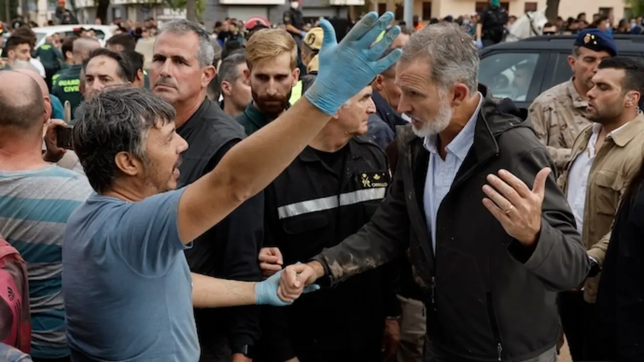 PAIPORTA (VALENCIA), 03/11/2024.- El rey Felipe (d) habla con un damnificado por la riada, durante su visita a Paiporta este domingo. Gritos de 'fuera', as&iacute; como lanzamiento de barro, est&aacute;n recibiendo a la comitiva de los reyes de Espa&ntilde;a, el presidente del Gobierno, Pedro S&aacute;nchez, y el president de la Generalitat, Carlos Maz&oacute;n, a su llegada al centro de Paiporta. Numerosas personas indignadas han recibido con insultos a la comitiva y se han encarado con ella, mientras que tanto el rey como la reina ha intentado mediar con j&oacute;venes que se les han acercado. EFE/ Biel Ali&ntilde;o