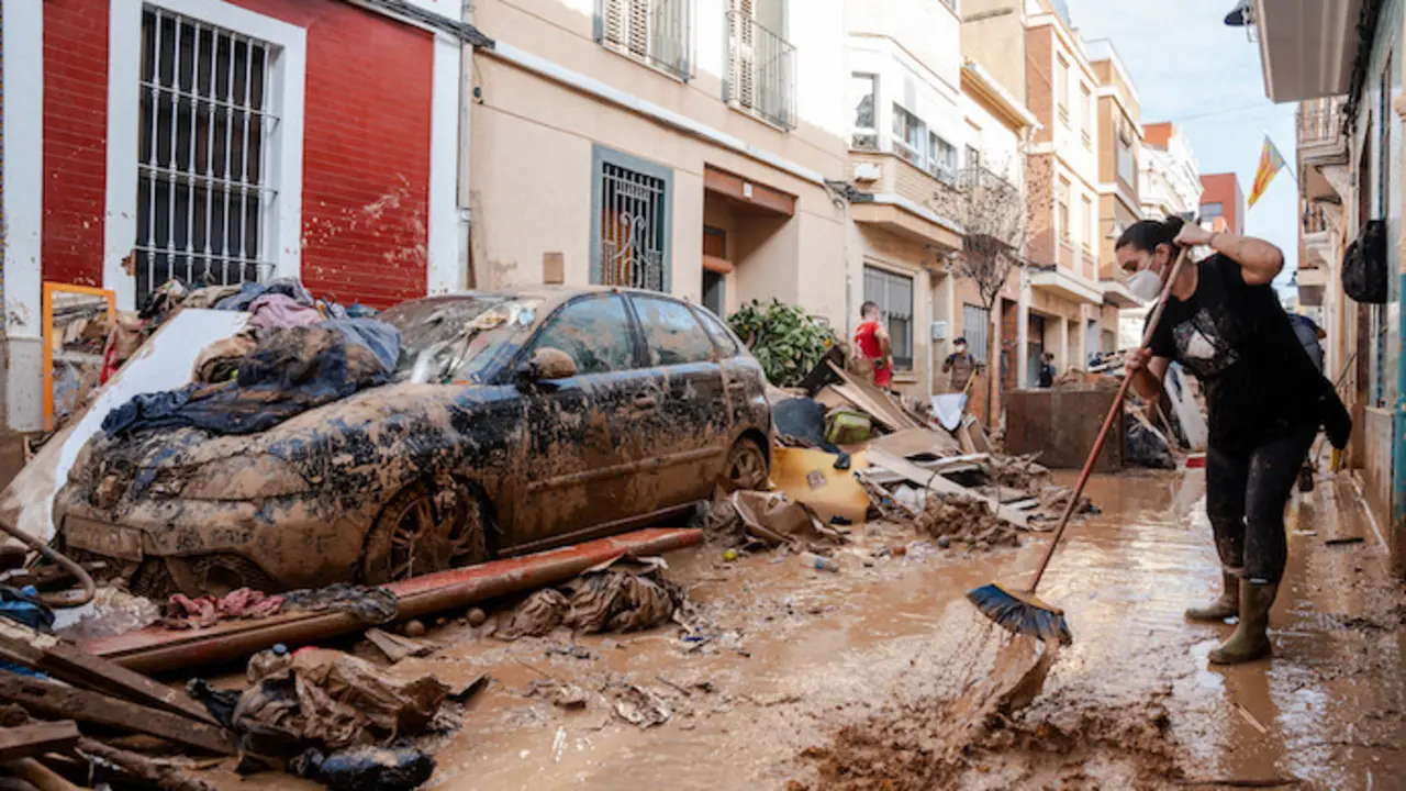 Una persona trata de limpiar el lodo en Catarrja. / EP