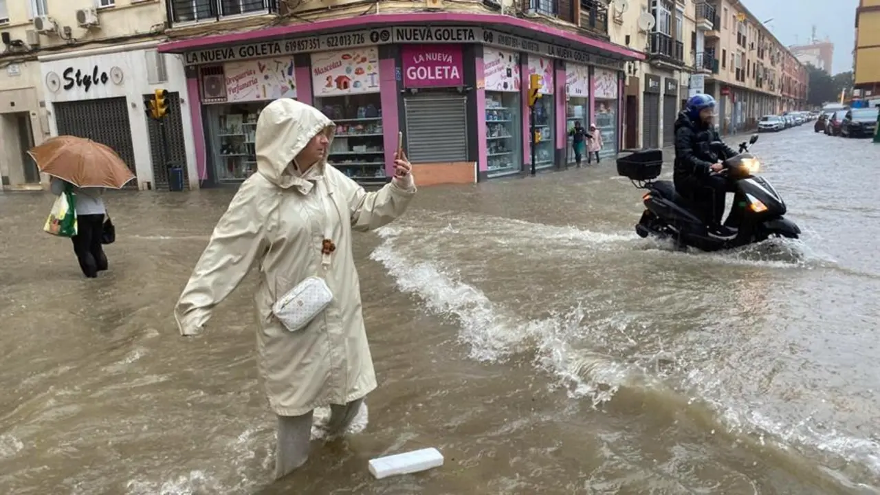 Una mujer hace fotos con el agua hasta las rodillas en M&aacute;laga donde las fuertes trombas de agua y granizo que se registran este mi&eacute;rcoles han causado inundaciones y la acumulaci&oacute;n de grandes balsas en algunas de las principales avenidas de todos los distritos de la ciudad.EFE/Mar&iacute;a Alonso