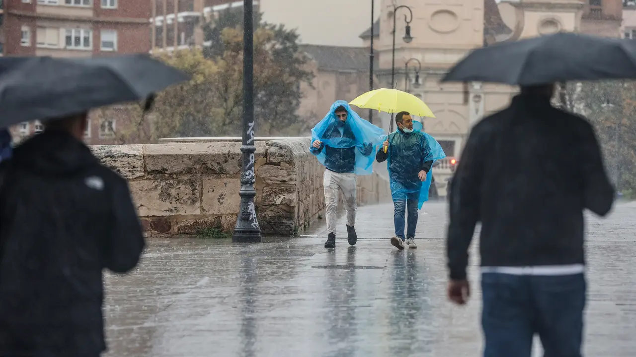 Dos personas con paraguas y chubasqueros caminan bajo la lluvia. / Rober Solsona