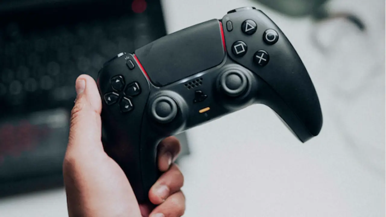Una persona con un mando de PlayStation. / A.E