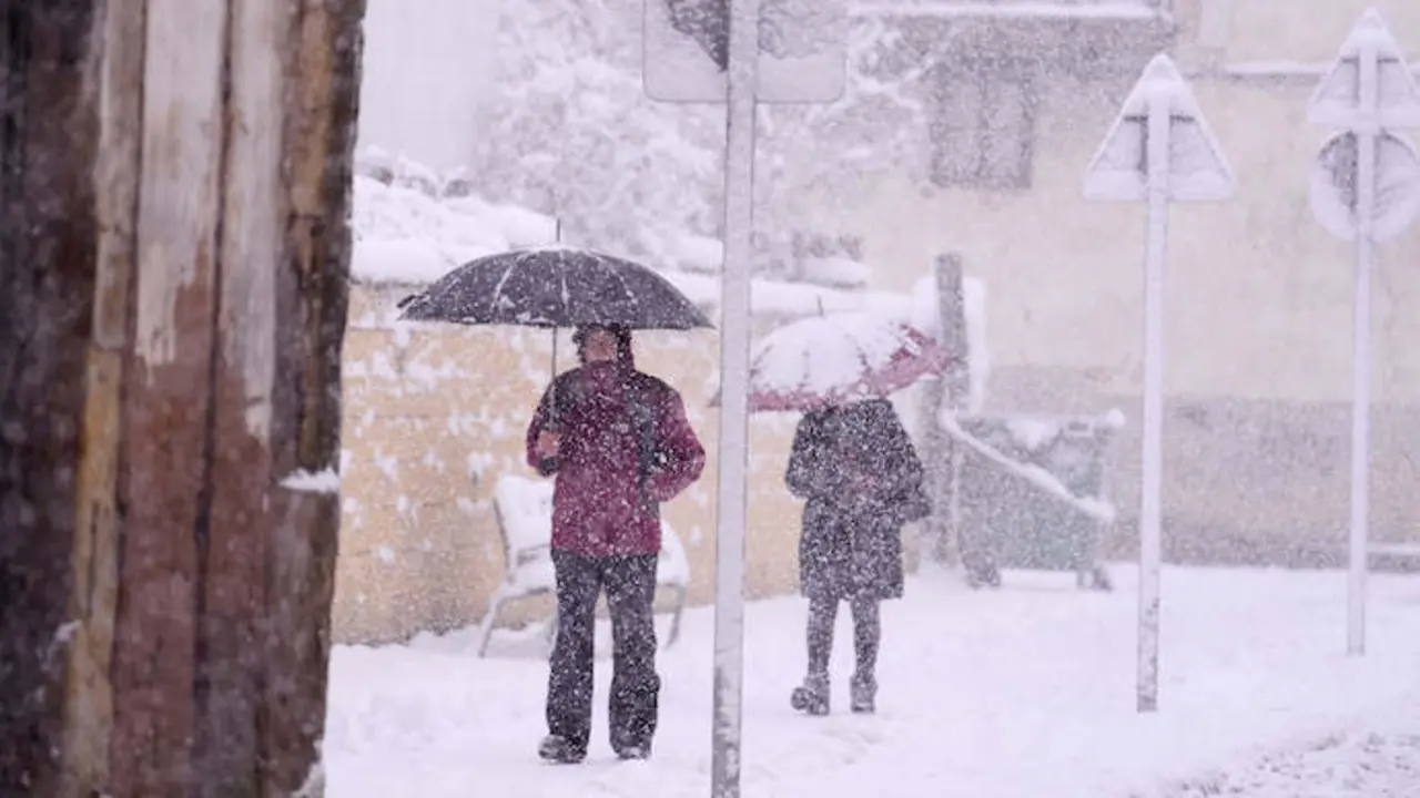 Dos personas caminan por una calle cubierta de nieve. / EP