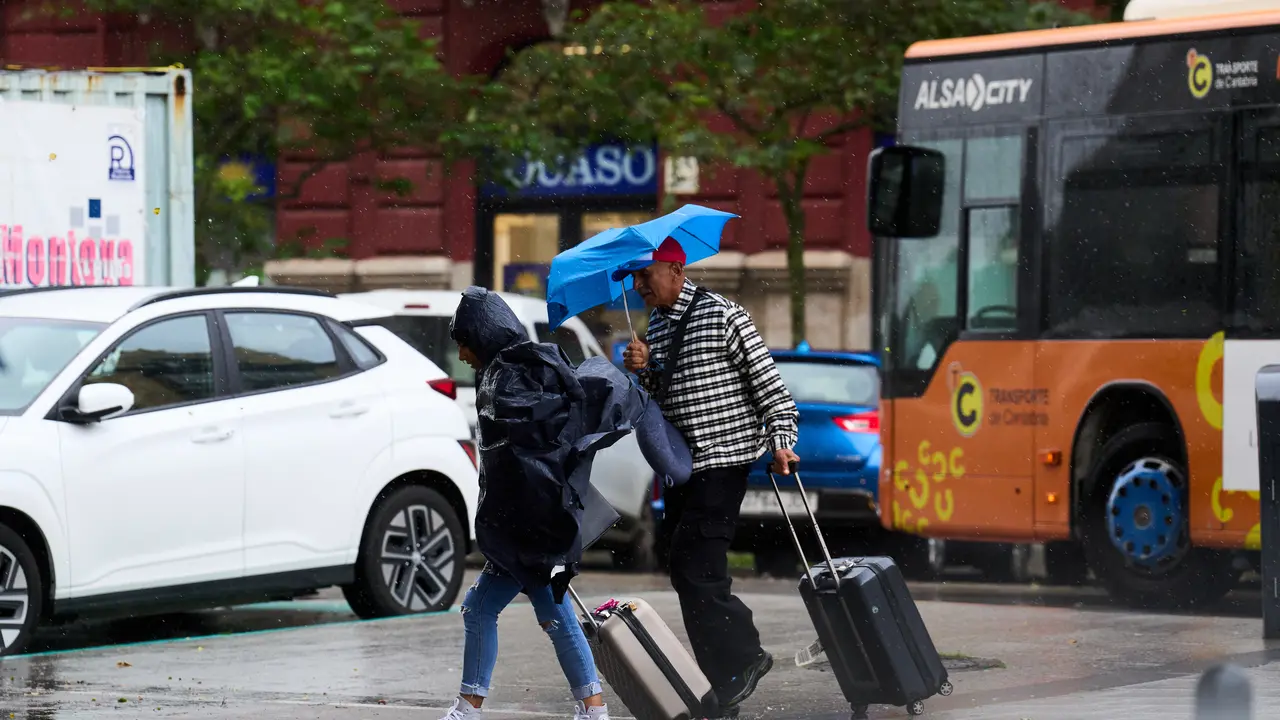 Varias personas se cubren de la lluvia y el viento con paraguas. /  Juanma Serrano