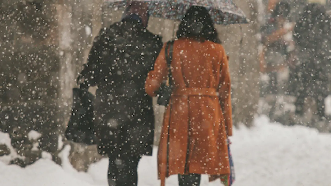 Dos personas caminan por la calle en un d&iacute;a de nieve. / A.E
